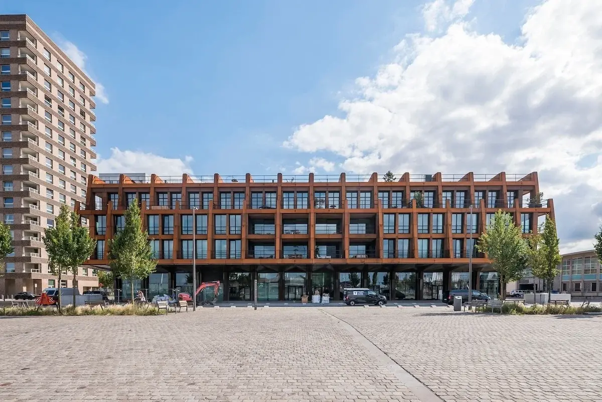 Edificio moderno con facciata in acciaio color ruggine su una piazza lastricata ad Anversa