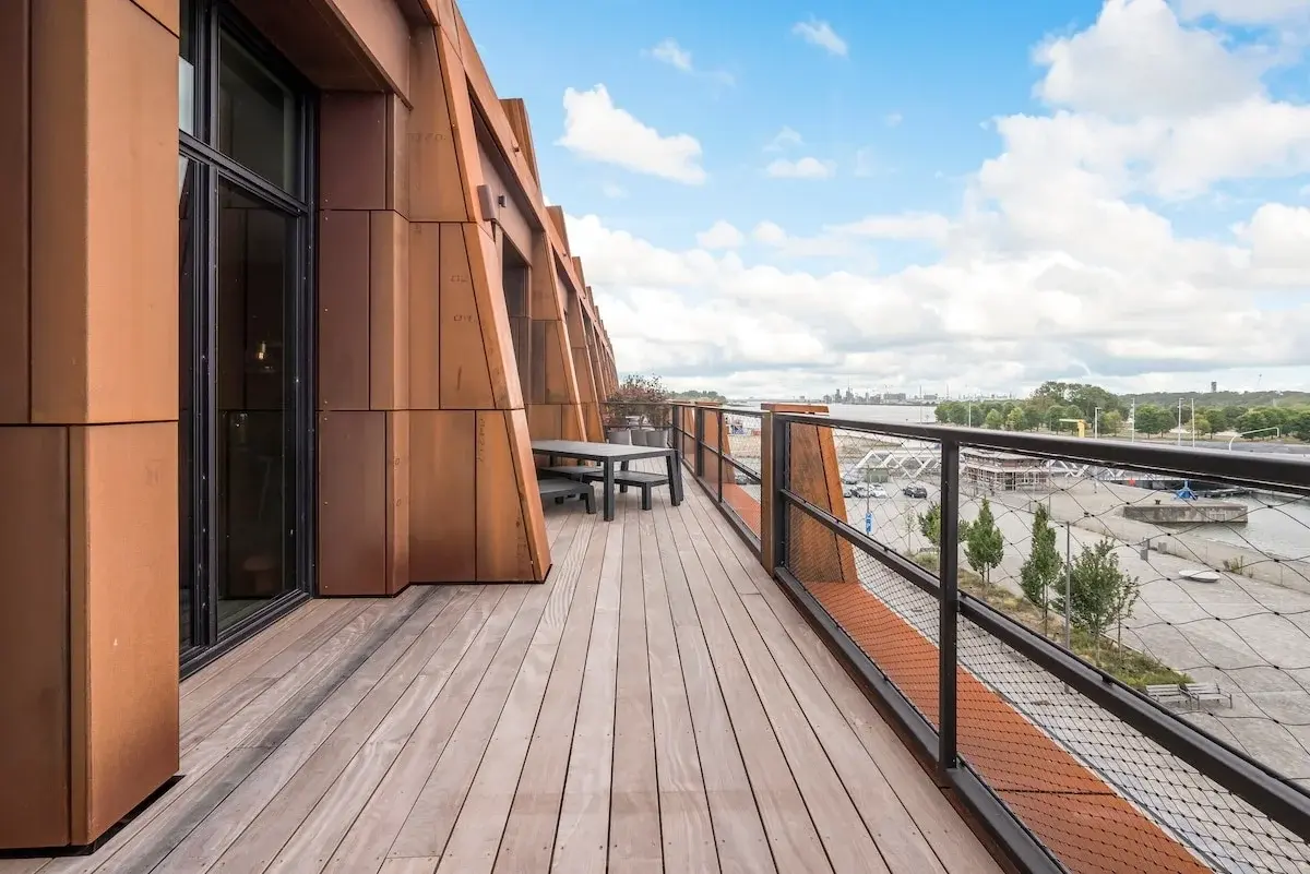 Modernes Apartmenthaus mit rostfarbener Stahlfassade an einem gepflasterten Platz in Antwerpen